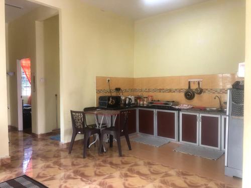 uma cozinha com mesa e cadeiras num quarto em Homestay Seri Hampar, Pendang em Pendang