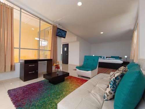 a living room with a couch and a room with a bed at HOTEL PANORAMA SOL in Chachagüí