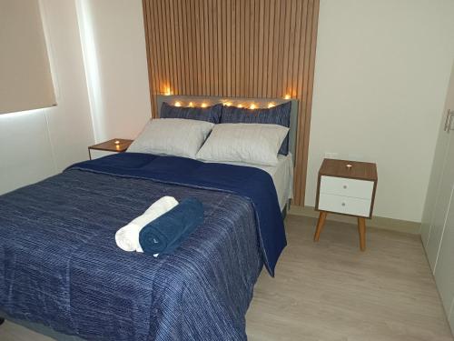 a bedroom with a blue bed with two towels on it at lovely apartament with hydromassage in Lima