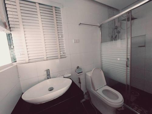 a white bathroom with a sink and a toilet at The Two-Bedroom Balcony House Tagaytay in Tagaytay