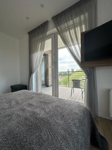 a bedroom with a bed and a large window at Ravėlino Apartment in Klaipėda