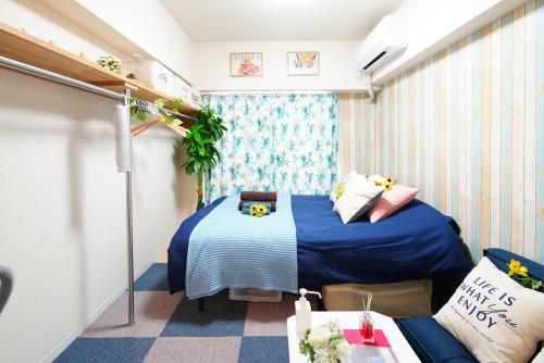 Habitación pequeña con 2 camas y sofá en SC Kameari 1003, en Tokio