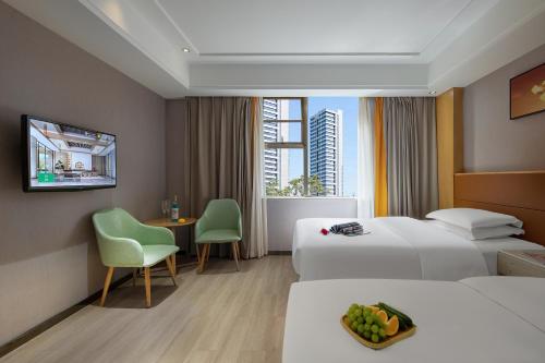 a hotel room with two beds and a table and chairs at Morninginn, Malan Mountain Metro in Changsha