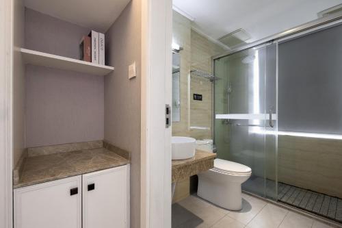 a bathroom with a toilet and a glass shower at Morninginn, Malan Mountain Metro in Changsha