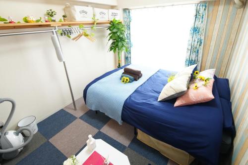 a room with a bed with blue sheets and pillows at Kameari 1003 Budget Stay High Floor Near Station Mall Disney Access in Tokyo
