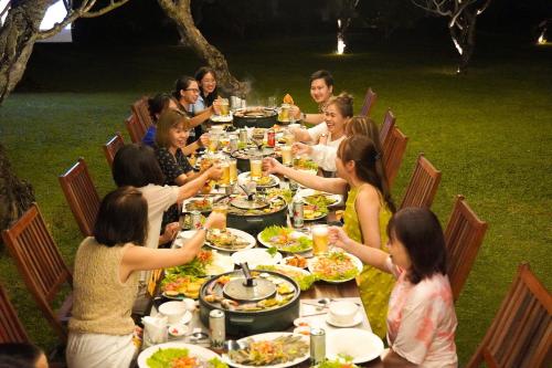 a group of people sitting around a table eating food at Pax Ana Doc Let Resort & Spa in Ninh Hòa