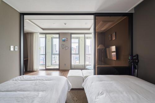 a hotel room with two beds and a mirror at Family Hotel & Arbol in Busan