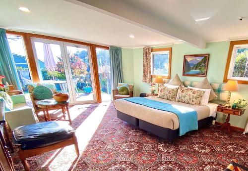 een slaapkamer met een bed in een kamer met ramen bij Ah House City B&B Nelson in Nelson
