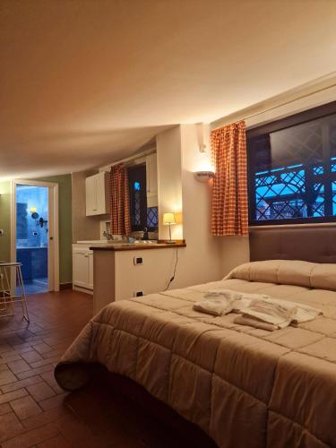 a bedroom with a large bed and a kitchen at DOMUS SAN CARLO LOFT in Caserta