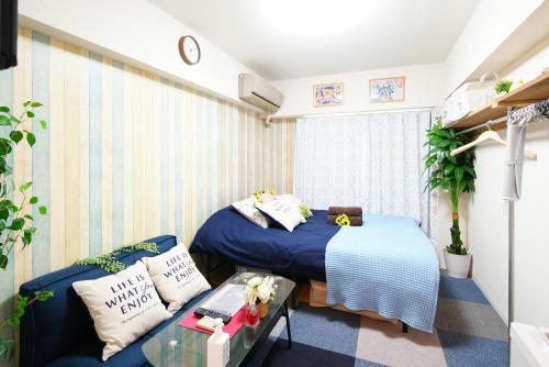 Habitación pequeña con cama y sofá en SC Kameari 1110, en Tokio