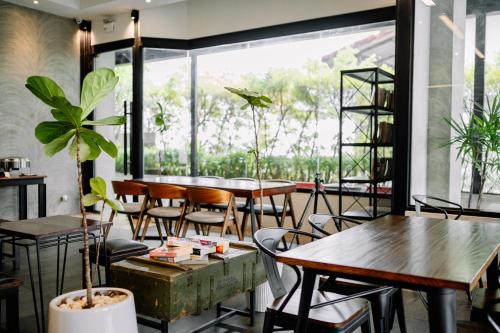 un restaurante con mesas y sillas y una gran ventana en S 2 Modern Boutique Hotel, en Vientiane