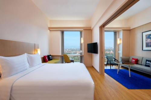 萬隆的住宿－宜必思萬隆一室公寓酒店，酒店客房设有一张大床和一张沙发。