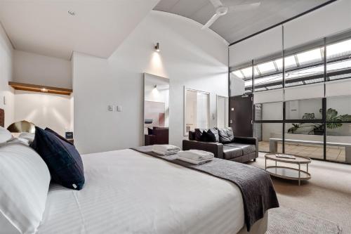 a bedroom with a large bed and a couch at 107 Apartments Margaret River in Margaret River Town