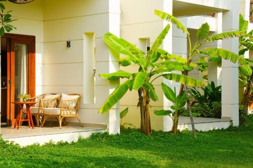 a house with a table and chairs on a porch at Pax Ana Doc Let Resort & Spa in Ninh Hòa