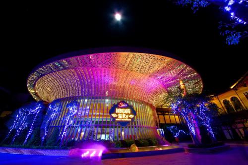 a building with a lit up facade with purple lights at Four Points by Sheraton Heyuan Resort in Heyuan