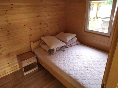 a small room with a bed in a log cabin at Domek letniskowy Zełwągi in Zełwągi