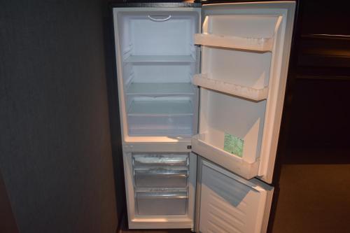 an empty refrigerator with its door open in a kitchen at Torifito Hotel & Pod Kanazawa in Kanazawa