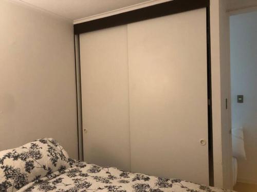 a bedroom with a bed and a white closet at Arriendo dpto o pieza por noche in San Pedro de la Paz