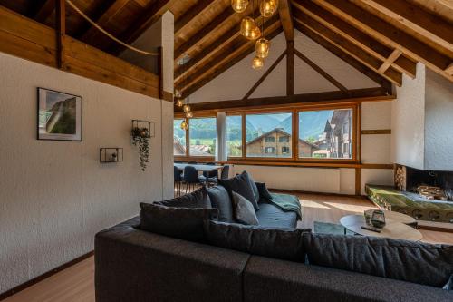 un grand salon avec un canapé et une cheminée dans l'établissement Jungfrau-View Apartment, terrace & free parking, à Wilderswil
