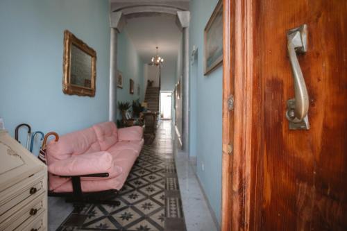 un salon avec un canapé rose et un couloir dans l'établissement Villa Valentina Versilia, à Viareggio