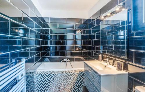 ein blau gefliestes Bad mit einer Badewanne und einem Waschbecken in der Unterkunft Awesome Home In Les Adrets-de-lestre With Wifi in Les Adrets-de-l’Estérel