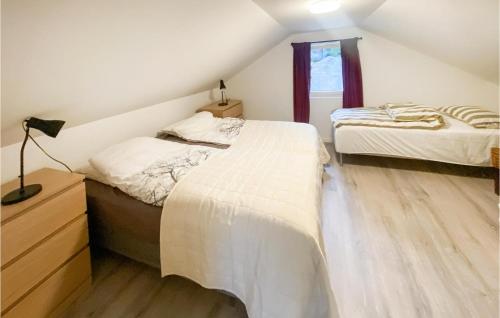 a attic bedroom with two beds and a window at Amazing Home In Bjryhamn With Wifi And 4 Bedrooms 