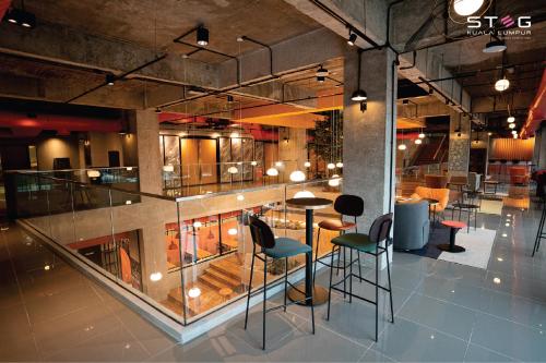 a lobby with a bar with chairs and tables at STEG Kuala Lumpur in Kuala Lumpur