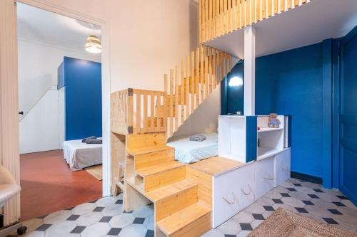 a room with a staircase and blue walls at Le petit marin, clim/wifi/quartier gare-arènes. in Nîmes