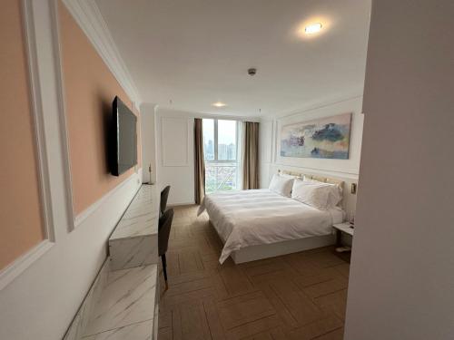 a white bedroom with a bed and a window at Magnificent International Hotel in Shanghai