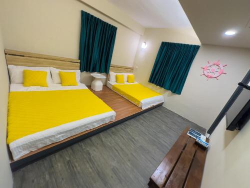 a bedroom with two beds with yellow pillows at 炎島 & 莎蔓民宿Salman in Green Island