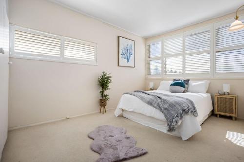1 dormitorio con 1 cama blanca grande y ventanas en Sunset Sanctuary Glenelg Sth, en Glenelg