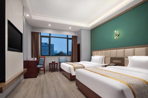 a hotel room with two beds and a flat screen tv at Morninginn, Xingsha Huiyi City in Changsha