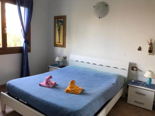a bedroom with a bed with two towels on it at Il mare cristallino dell'Ogliastra- Marina di Tertenia in Tertenìa