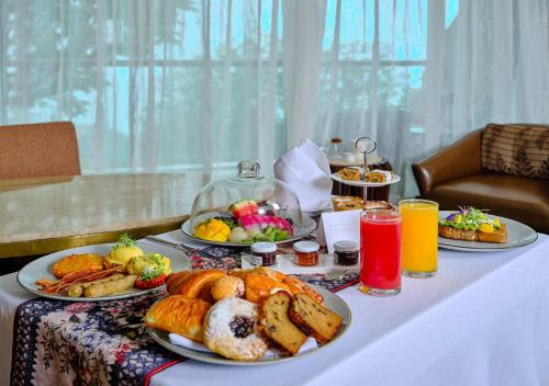 a table with plates of food and drinks on it at JW Marriott Mussoorie Walnut Grove Resort & Spa in Mussoorie