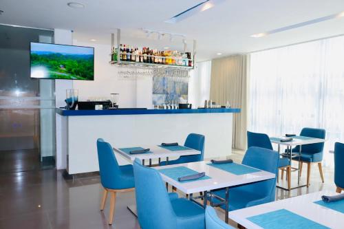 un restaurante con mesas y sillas y un bar en Stacia Hotel powered by Cocotel en Cebu City