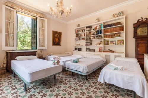 a bedroom with three beds and a chandelier at Casanova in Vallromanes