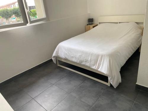 une chambre avec un lit blanc avec une fenêtre dans l'établissement Studio6 proche Fac climatisé, à Albi