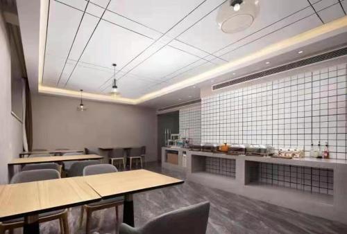 a large room with tables and chairs and a counter at Morninginn, Xingsha Huiyi City in Changsha