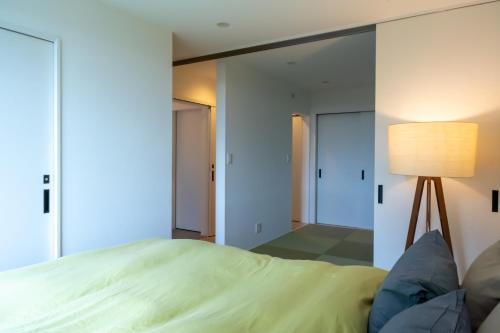 a bedroom with a bed and a lamp at Yugawara Vacation House in Yugawara