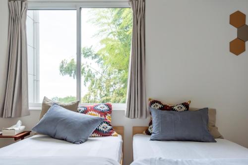 two beds in a room with a large window at Yugawara Vacation House in Yugawara