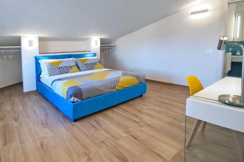 a bedroom with a blue bed and a desk at Villa Paradiso in Scopello
