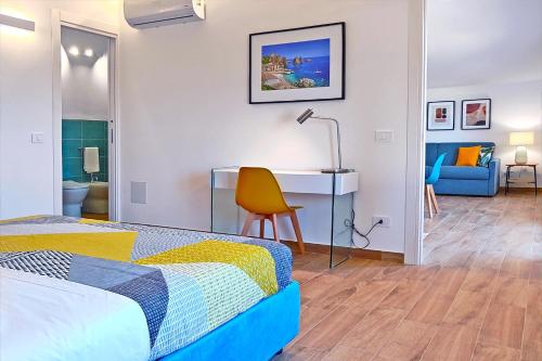 a bedroom with a bed and a desk and a chair at Villa Paradiso in Scopello