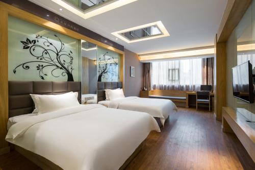 a hotel room with two beds and a television at Morninginn, Xinhua Railway Station in Xinhua