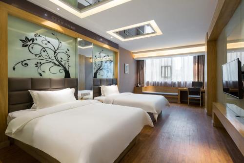 Una habitación de hotel con dos camas y un televisor. en Morninginn, Xinhua Railway Station, en Xinhua