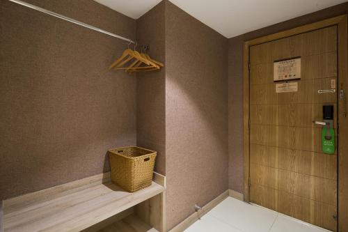 a room with a closet with a basket and a door at Morninginn, Xinhua Railway Station in Xinhua