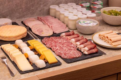 a table with different types of meats and cheese at Hotel Le Colombier in Colmar