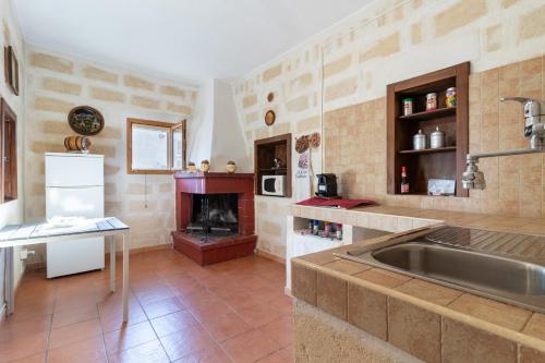 a kitchen with a sink and a fireplace at Villa Maria in Castellaneta