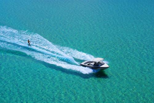 a man on a speed boat in the water at Nissiotiko Studios & Apartments in Drios