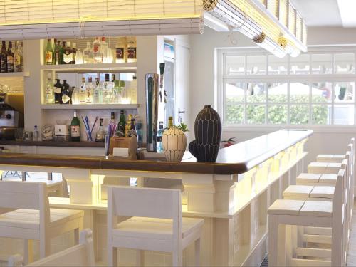 a bar in a restaurant with white stools at Hotel Els Pins in Platja  d'Aro