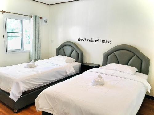 dos camas sentadas una al lado de la otra en una habitación en บ้านวิรา ห้องพัก Baan Wira en Khon Kaen